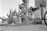 Crossing the Line during WWII. Sailors blacked up and wearing grass skirts doing what may be their impression of a Maori dance while on an African troop convoy. Photo: Lt. C. J. Ware. Imperial War Museum A5180