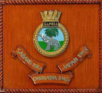 A wooden HMS Gambia crest with Battle Honours