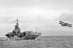 Fairey Albacores of No 820 Squadron Fleet Air Arm from HMS Formidable in the Indian Ocean during WWII. One of the aircraft has just flown off the aircraft carrier whilst two more can be seen on deck. Photographed from HMS Warspite. Photo: Lt. D. C. Oulds. Imperial War Museums A 10657