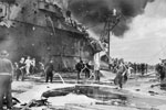 Firefighters busy on board HMS Formidable after a Japanese suicide plane had crashed on the flight deck. The rear part of the aircraft carrier's island can be seen, it is badly scorched whilst the flight deck is covered in foam and water. HMS Formidable was hit by a Kamikaze on May 4 and again on May 9. Imperial War Museums A 29310