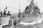In November 2001, Ray Holden sent me this photograph taken in 1951 from HMS Liverpool, the ship he served on. He said "The picture is of 1st Cruiser Squadron in the Med 1951, the cruiser trying to take our stern off is HMS Kenya." At first the ship was thought to be HMS Gambia but it is HMS Kenya as there are no director platforms on the front of the bridge. HMS Gambia had platforms that jutted out above B turret.